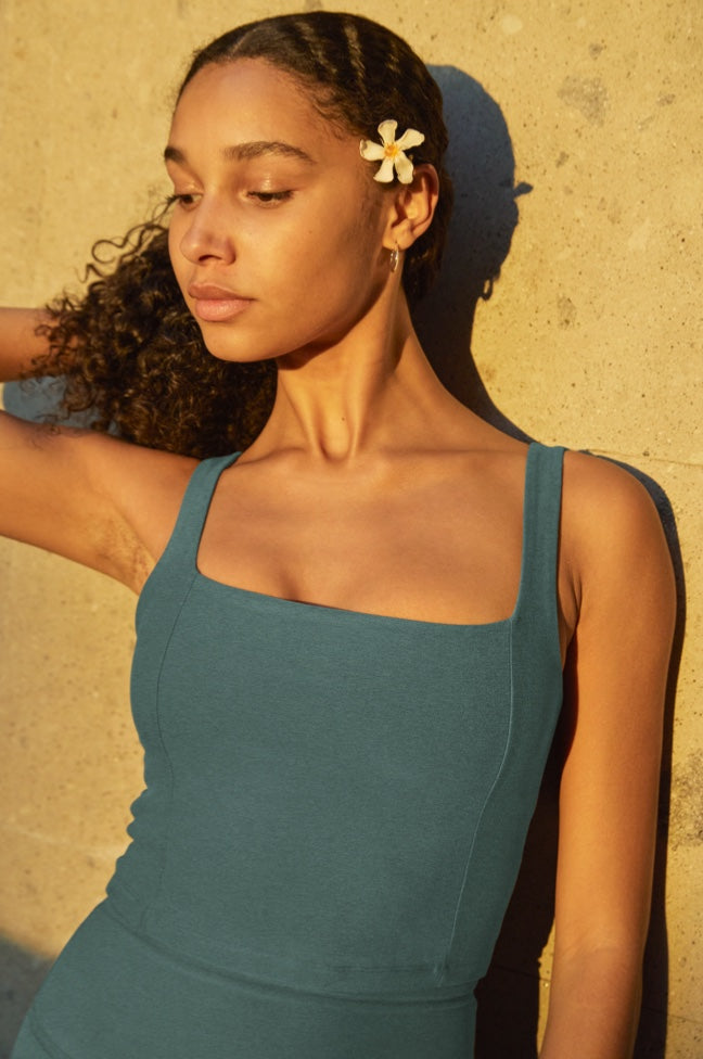 model is wearing a green square neck cropped tank. 