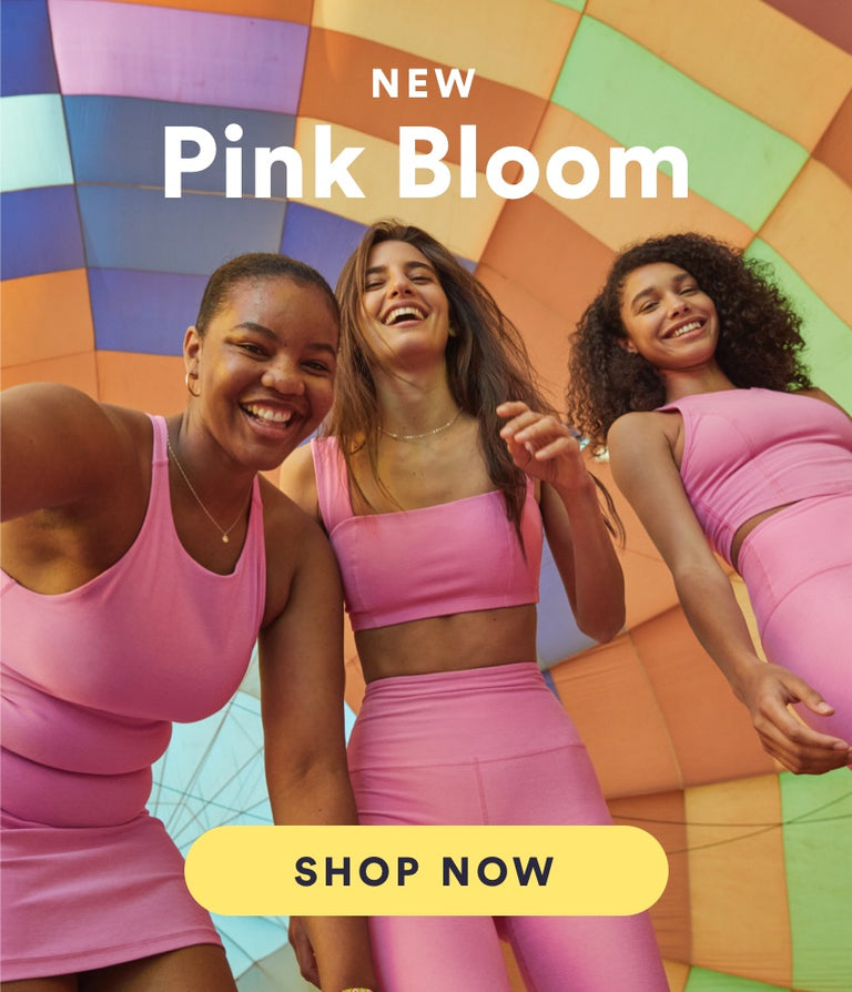 model on the left is wearing a pink highneck mini skirt. model in the center is wearing a pink square neck bra top and pink high-waisted capri flare pants. model on the right is wearing a pink highneck cropped tank and pink high-waisted biker shorts. 