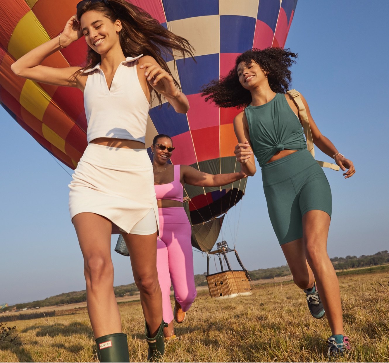 model on the left is wearing a white cropped ribbed tank and white ribbed mini skirt. model in the center is wearing a pink square neck bra top and pink high-waisted flare cropped pants. model on the right is wearing a green tank top and green high-waisted biker shorts. 
