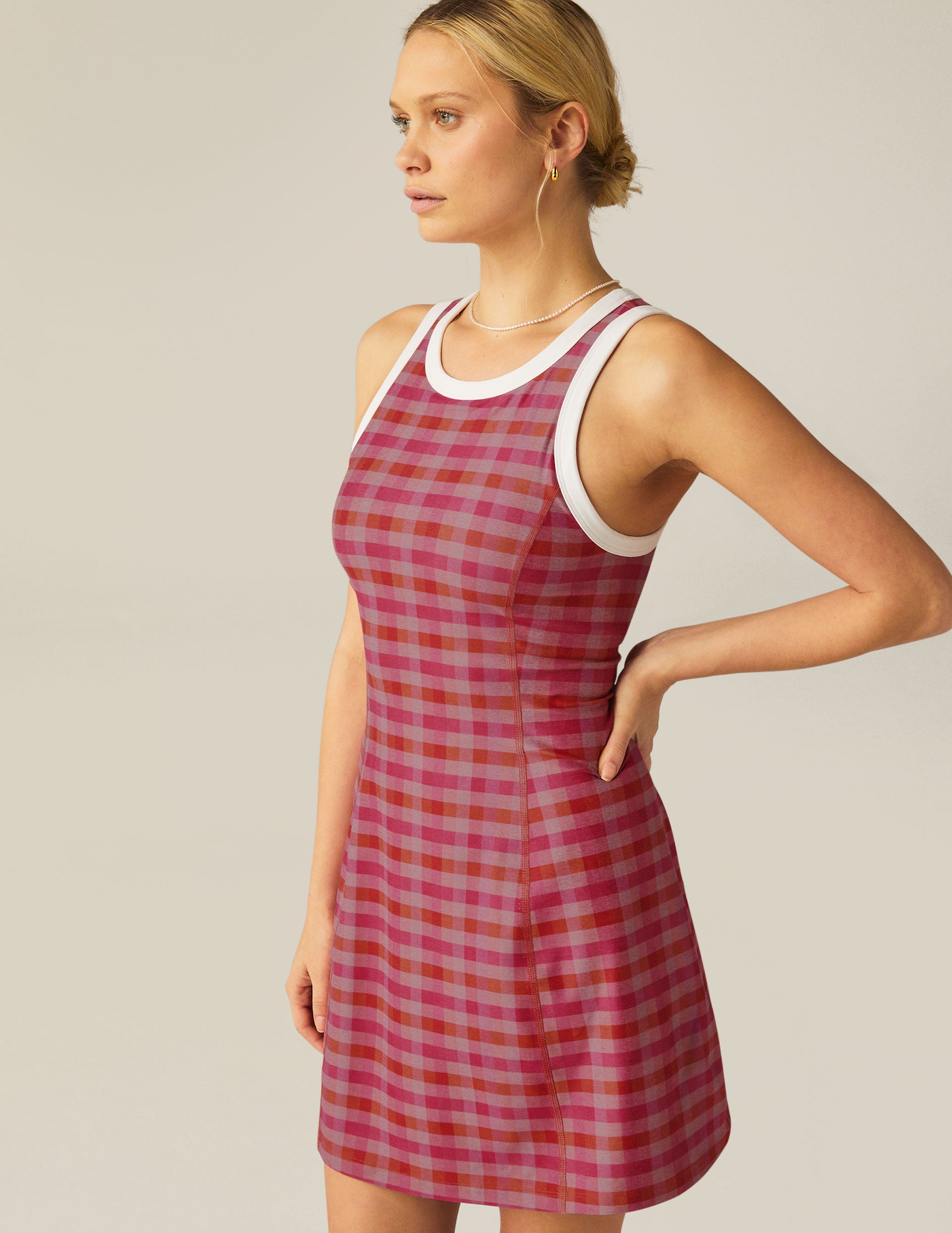 pink gingham printed mini dress with white outlining on arm holes and neckline. 