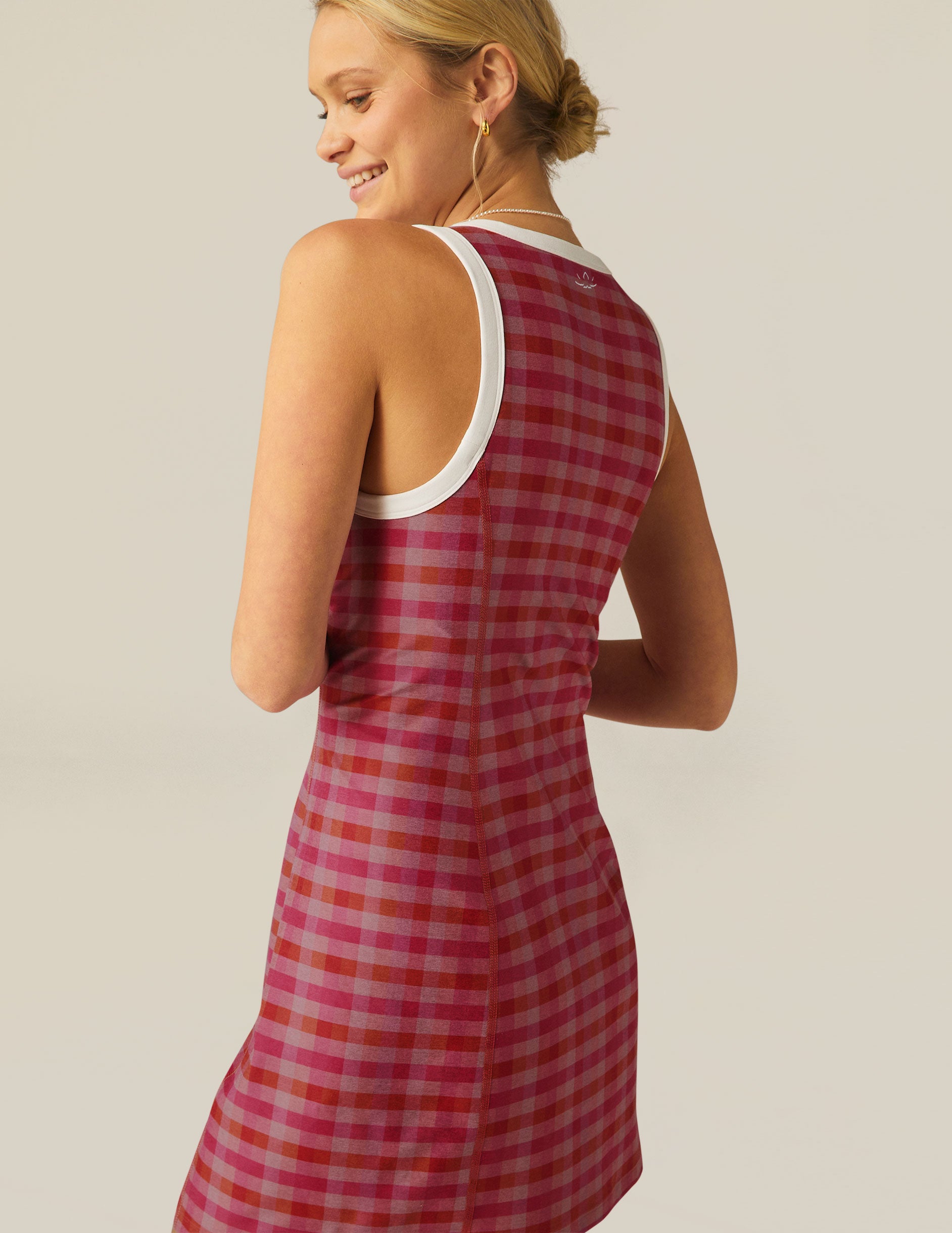 pink gingham printed mini dress with white outlining on arm holes and neckline. 